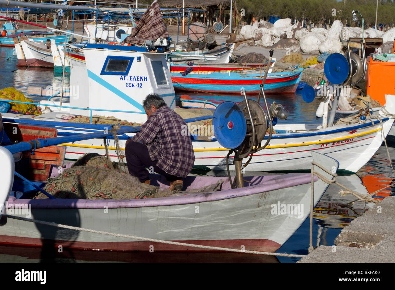 Fisherman working on nets Quay side Skala Kalloni harbour Lesbos Stock Photo