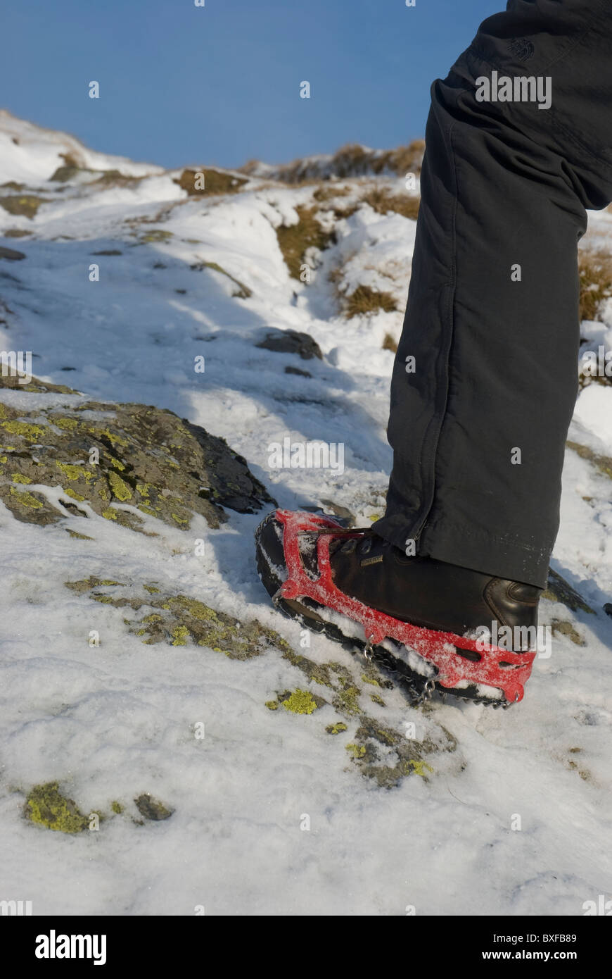 Walking boot with microspike crampons attached. Stock Photo