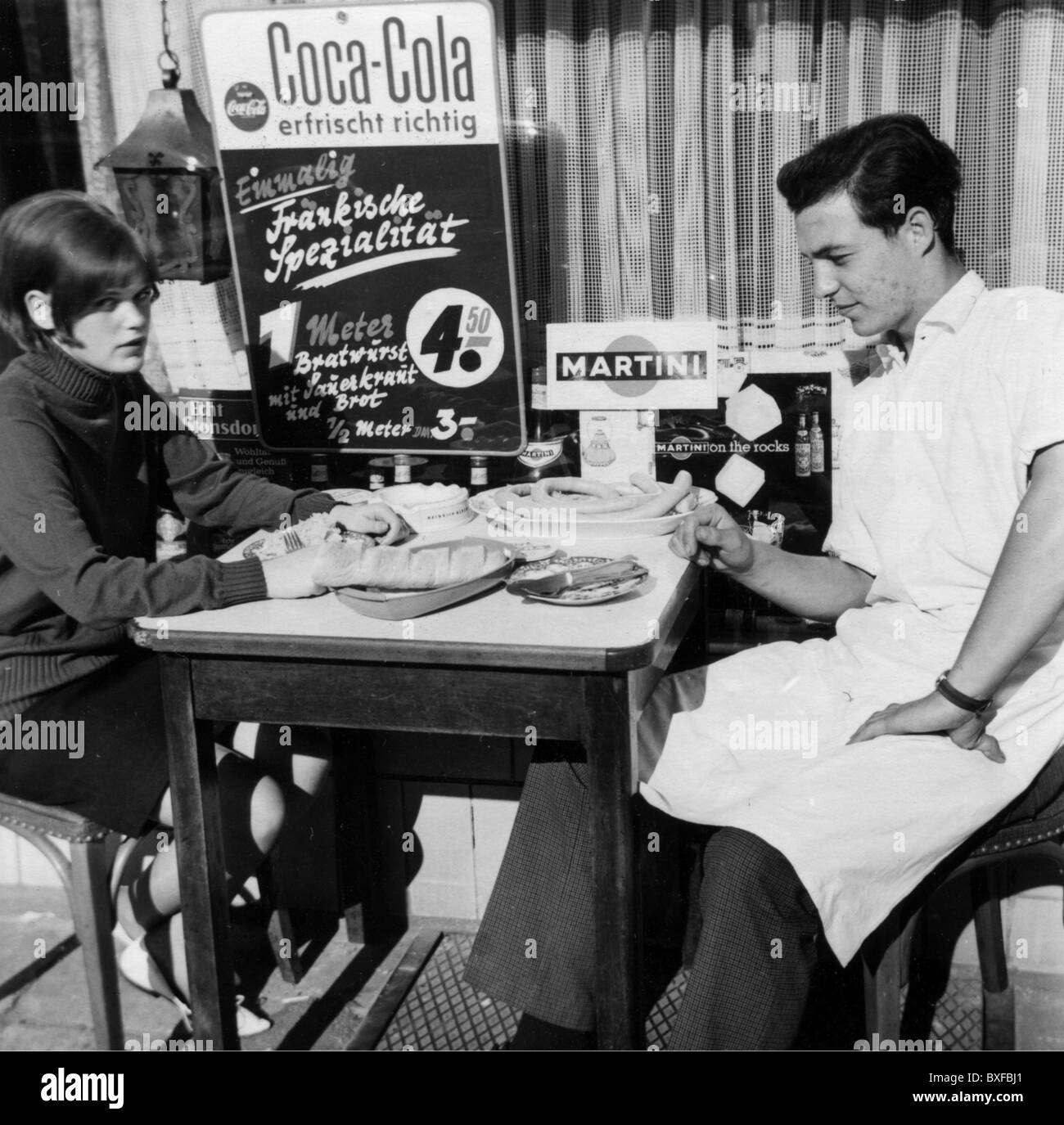 advertising, beverages, coke, man and woman having a meal in front of a shop window with a Coca Cola advertising sign, Germany, 1960s, Additional-Rights-Clearences-Not Available Stock Photo