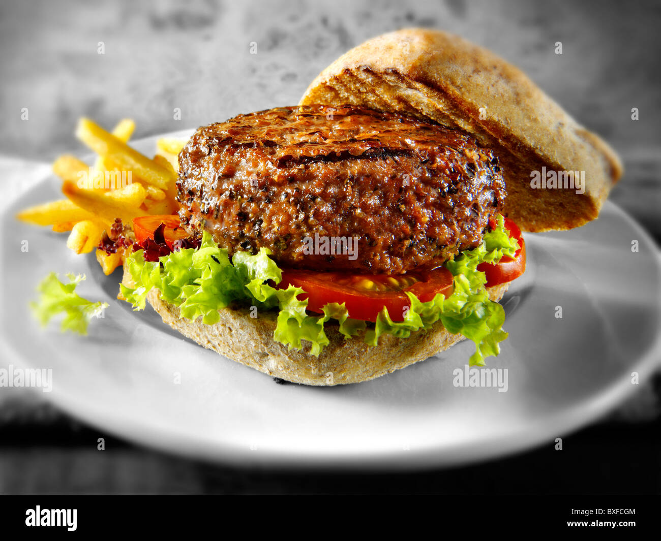 Peppered beef burger with chips and wholemeal bun Stock Photo