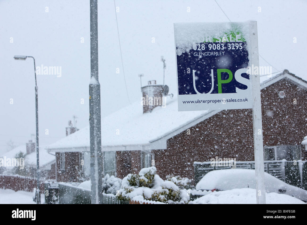 estate agents sign coated in snow on a cold snowy winters day Belfast