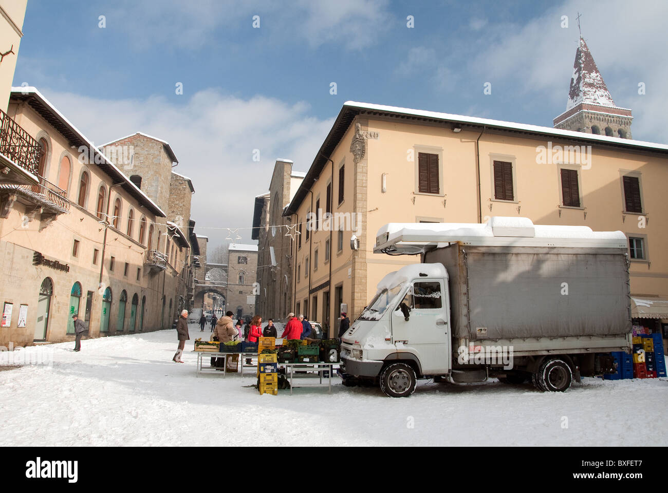 Market fruit seller in the piazza of Tuscan town of Sansepolcro in December snow Stock Photo
