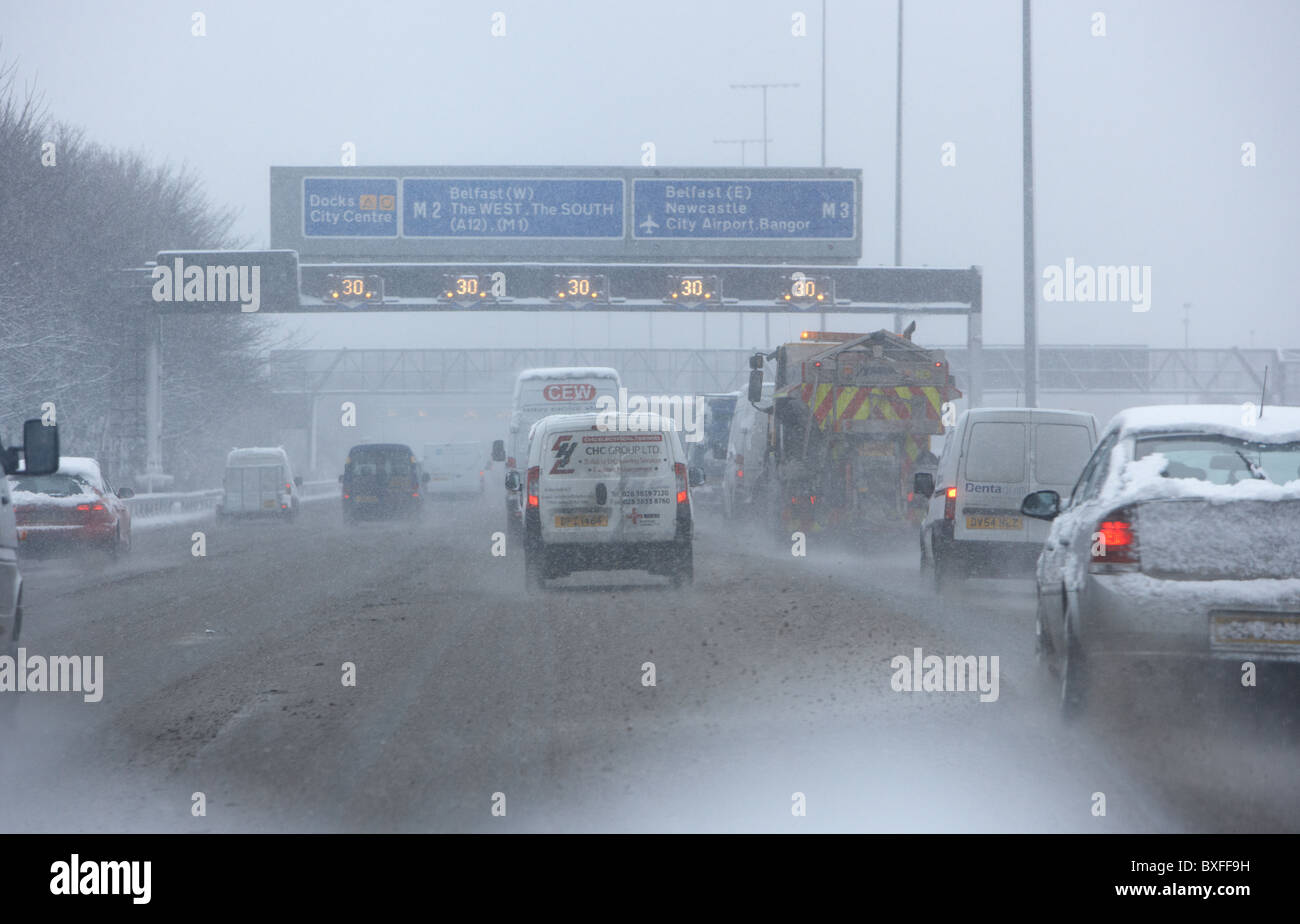 gritting lorry snowplough travelling down motorway on a cold snowy winters day Belfast Northern Ireland Stock Photo