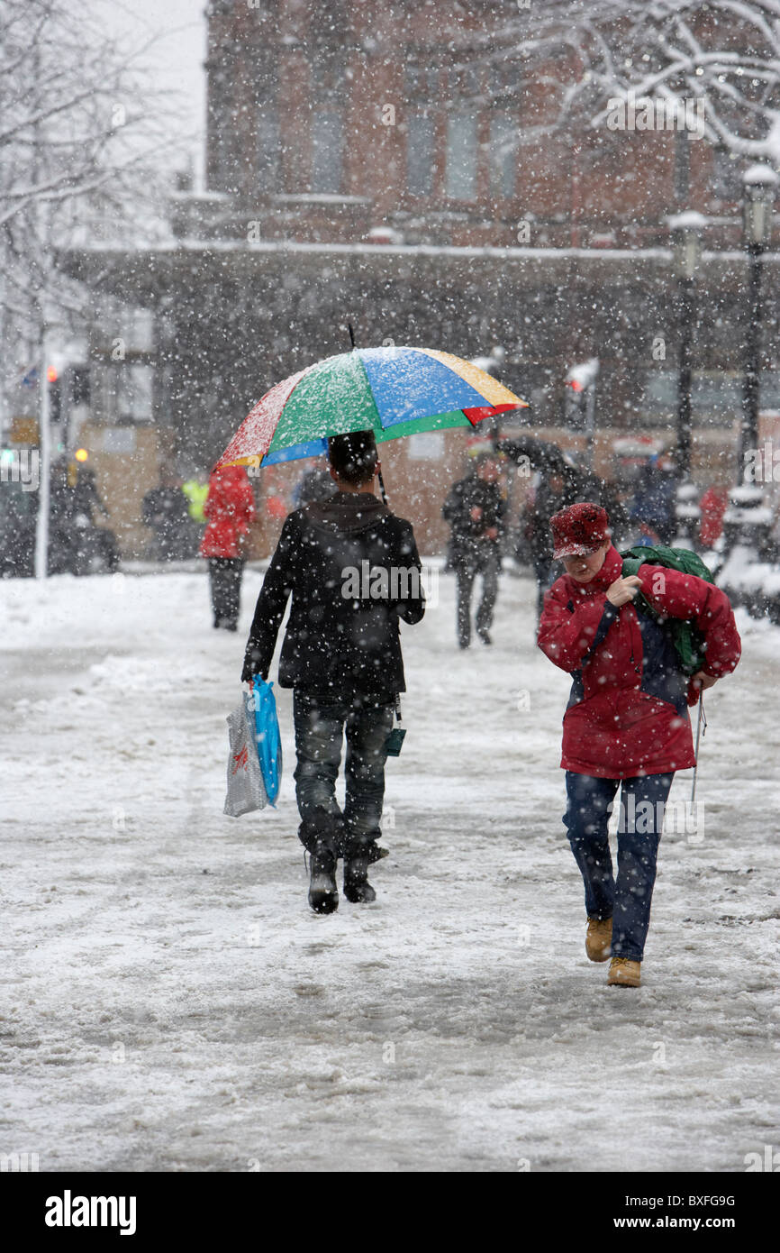 people in warm winter clothing out christmas shopping on a cold snowy winters day Belfast Northern Ireland Stock Photo