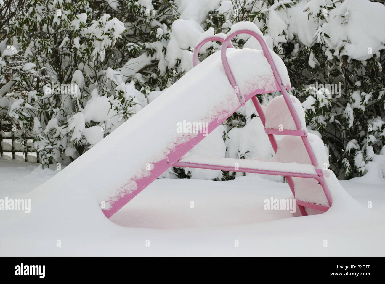 Heavy snow covering a pink slide. Stock Photo