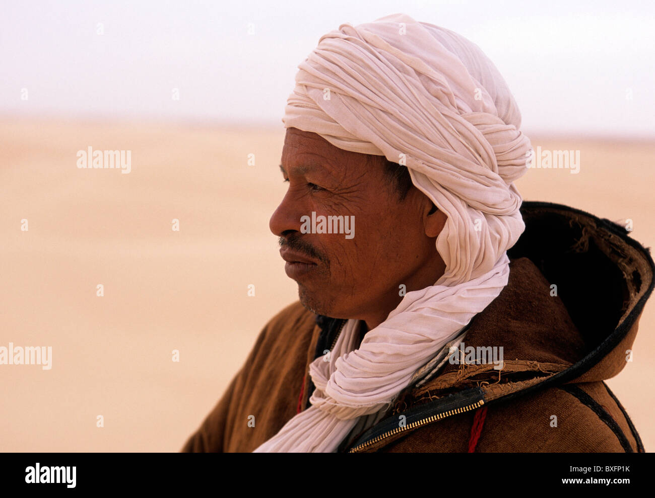 Tunisian man in traditional Berber dress on the edge of the Sahara desert near the oasis town of Tozeur- Tunisia Stock Photo