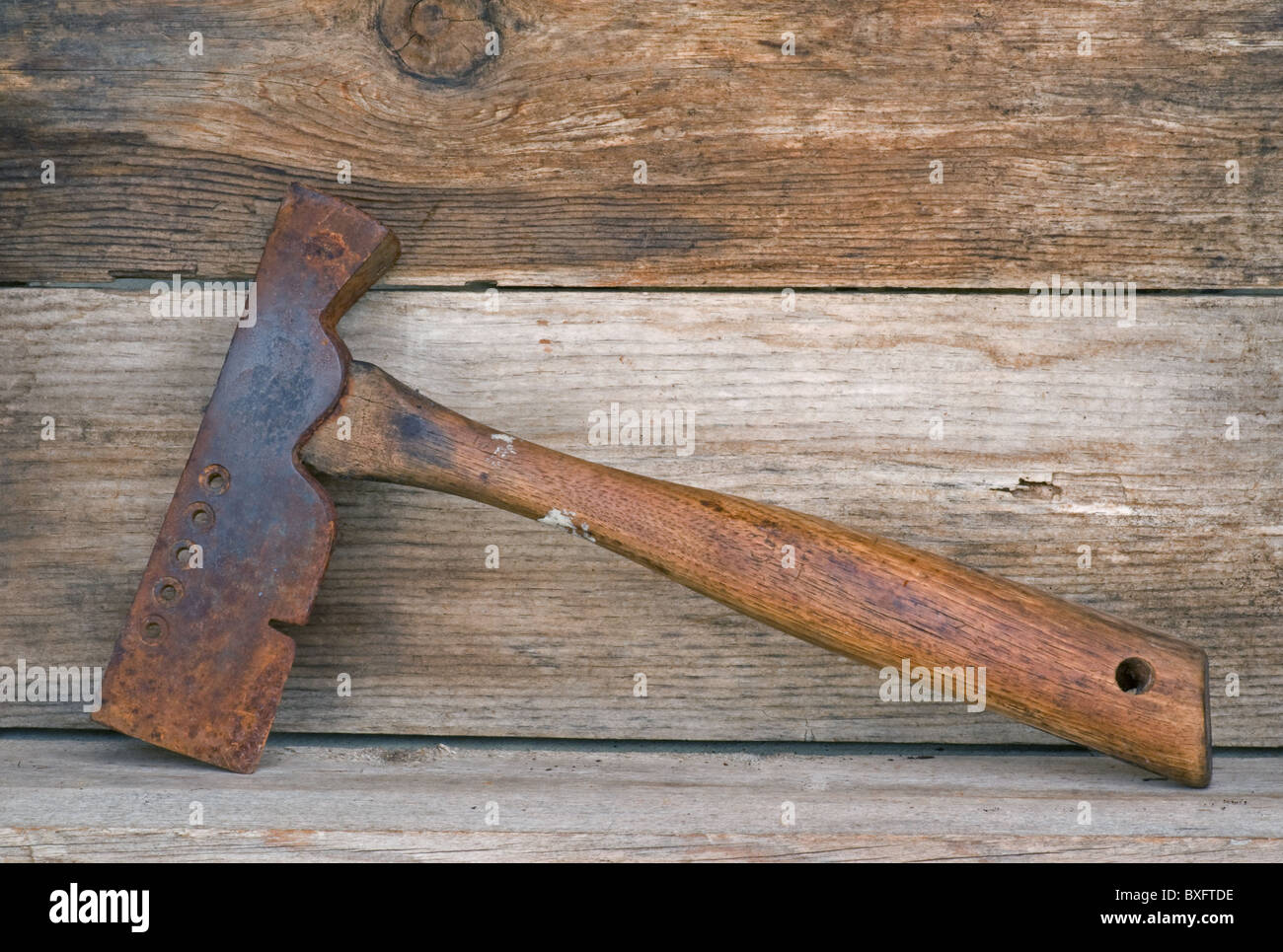 Old iron shingle hammer ax tool resting on an old wooden shelf Stock Photo  - Alamy