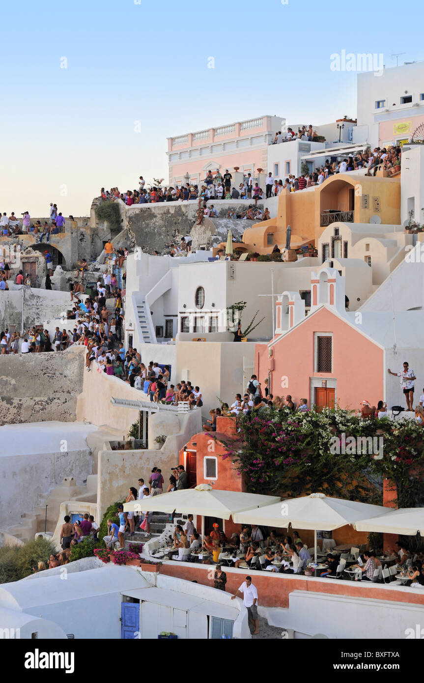 People on roofs and streets of Oia watch Santorini sunset Stock Photo