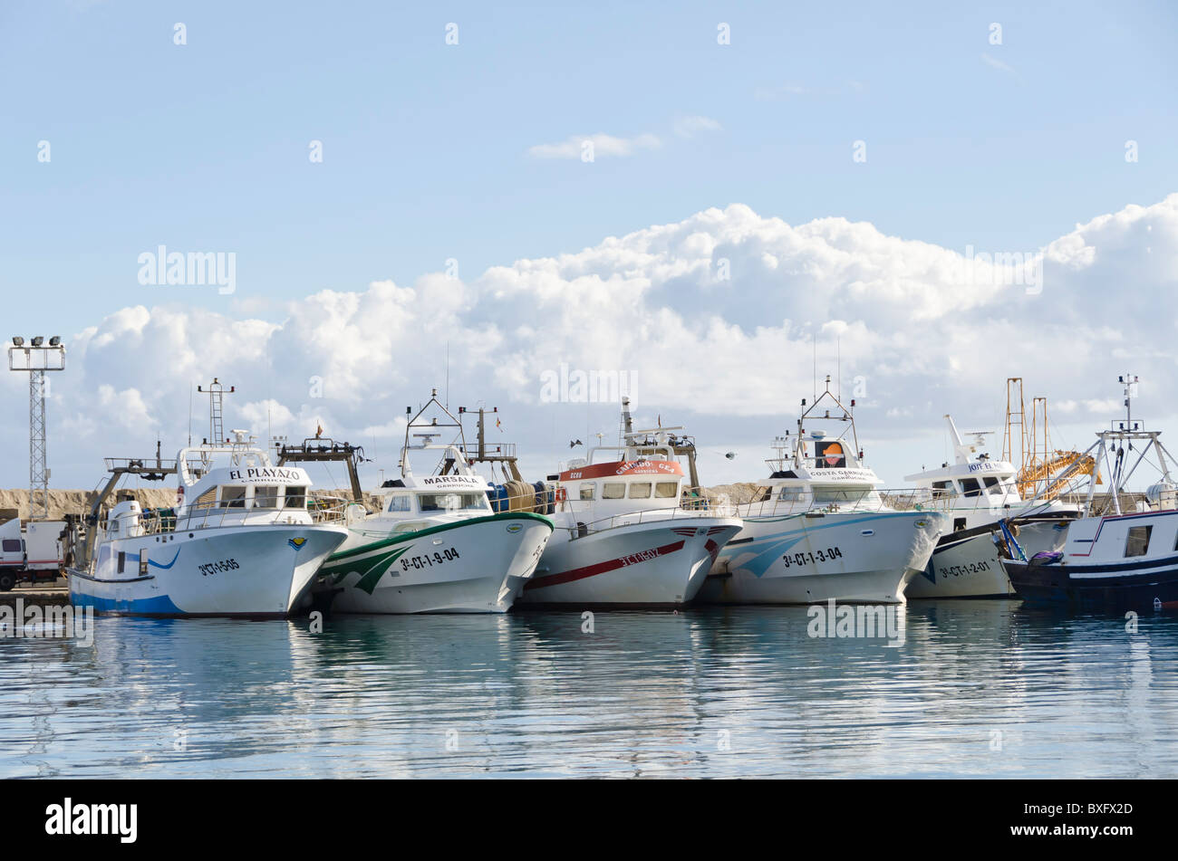 Fishing Boats in Garrucha harbour, Spain on a Sunday lunchtime. The Fishing Boats are lined up in the harbour ready for their next outing. Stock Photo