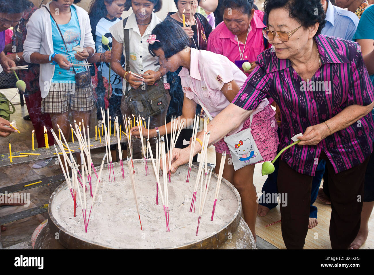 Buddhist worshipers light incense as offerings to Buddha at Wat Phra Sri Sanpetch Buddhist