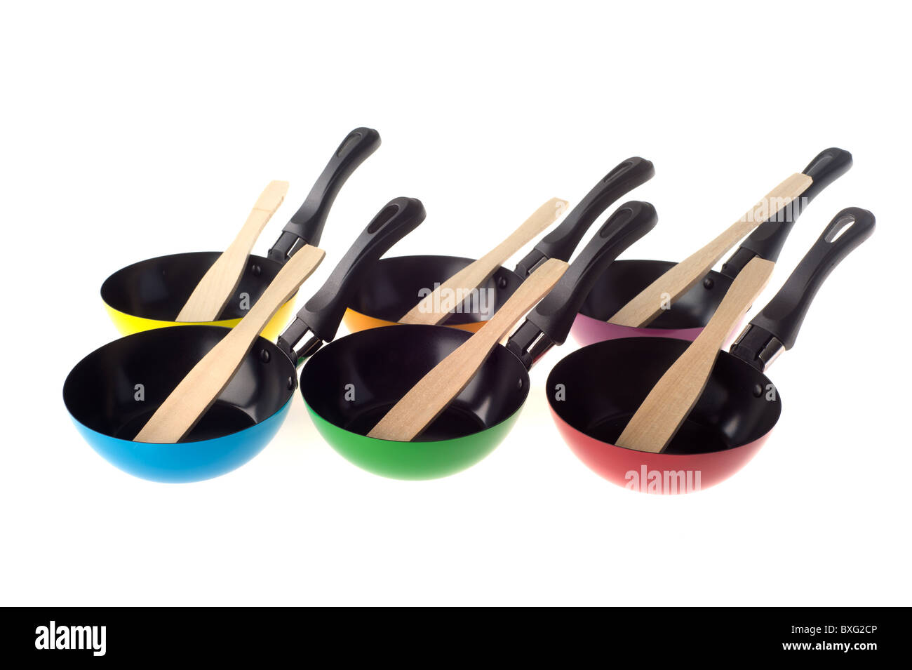 Many stacked colorful frying pans isolated over white Stock Photo