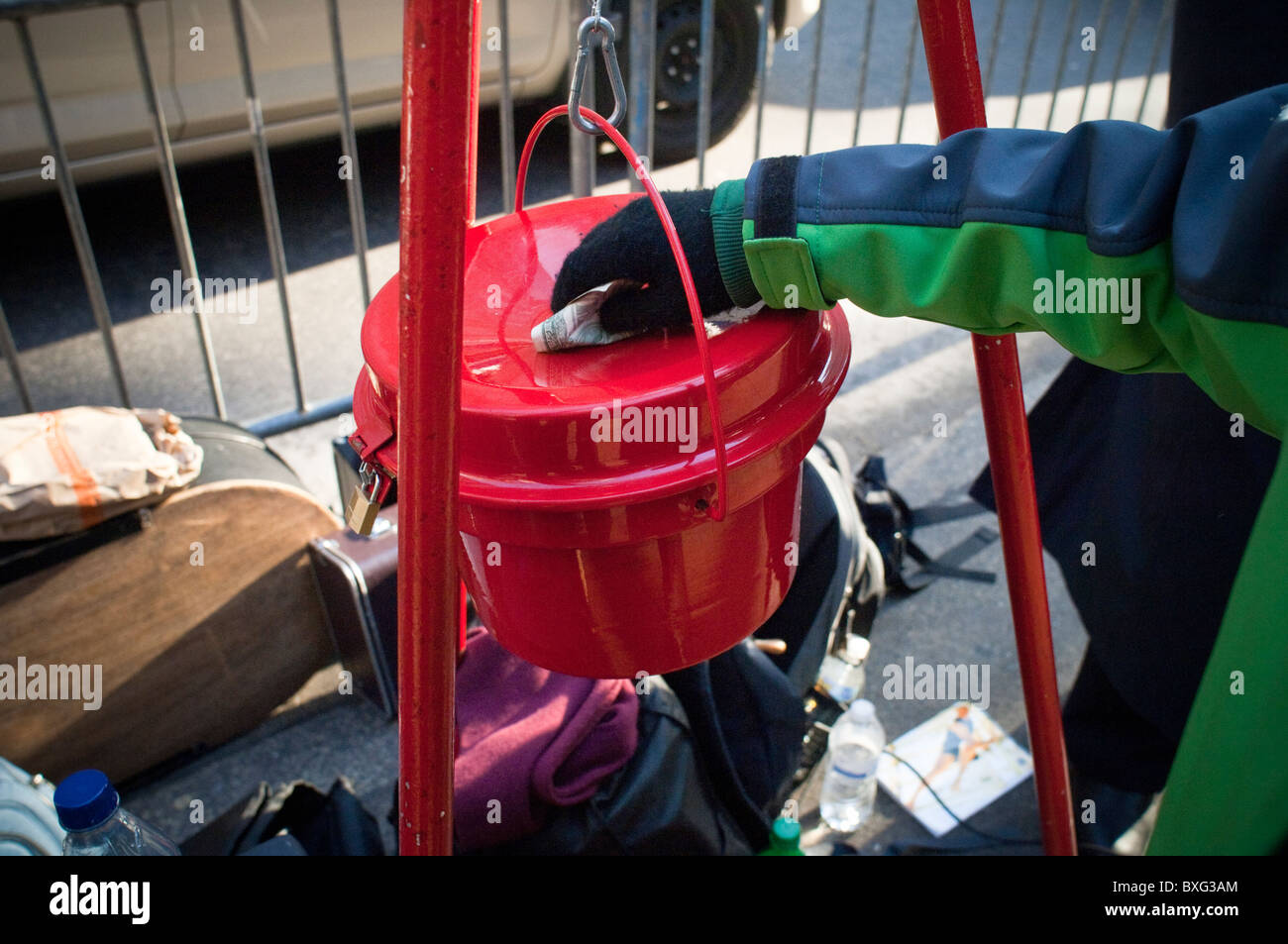 A passerby donates money to the Salvation Army's red kettle in Rockefeller Center in New York Stock Photo