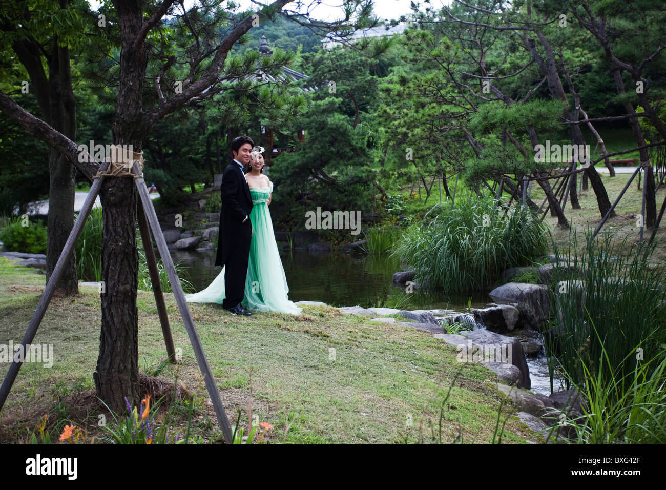 Korean wedding couple posing for photographer in a Seoul's park, South Korea Stock Photo