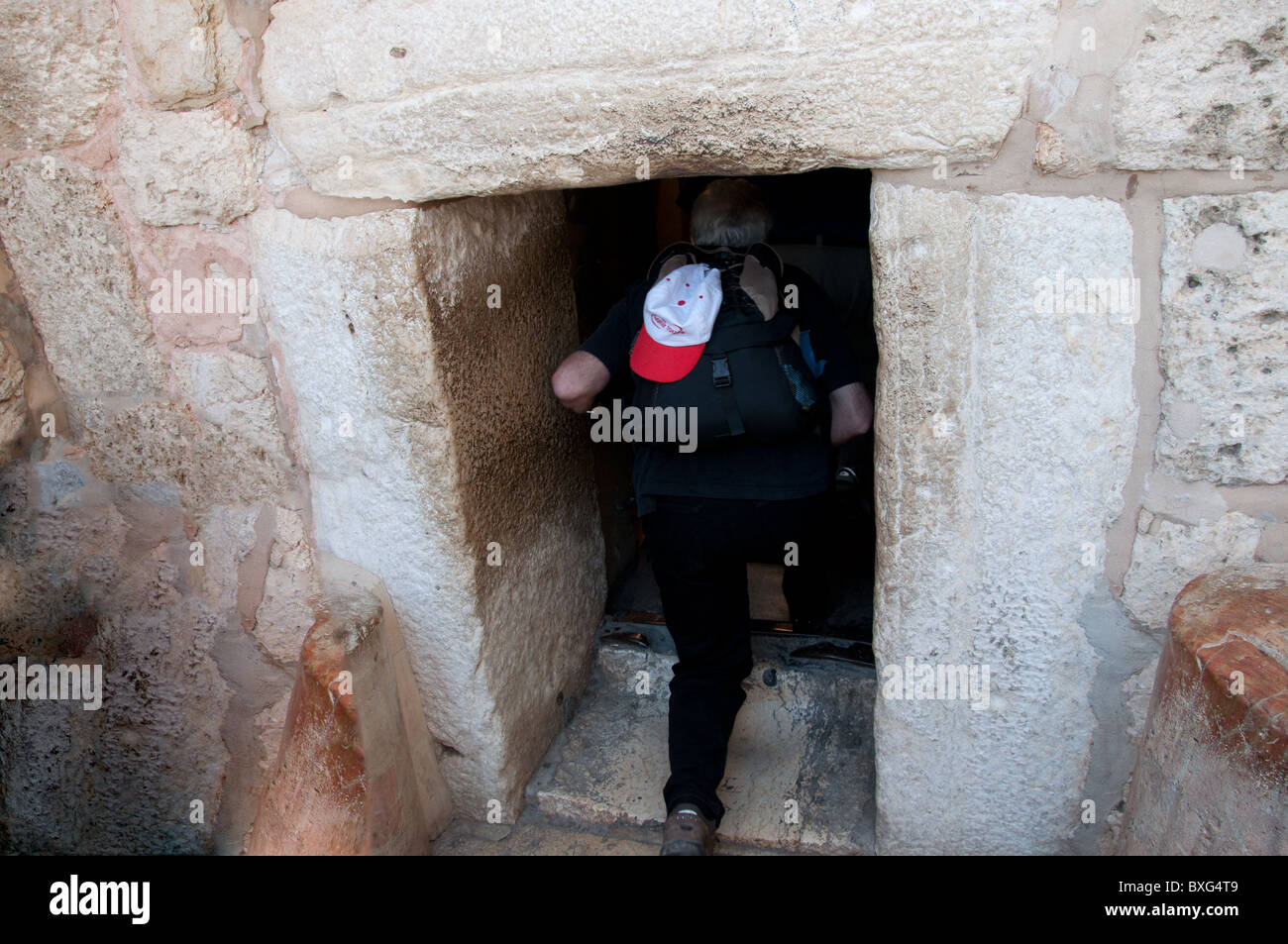 A Christian pilgrim entering the Church of the Nativity in Bethlehem through the Door of Humility. Stock Photo