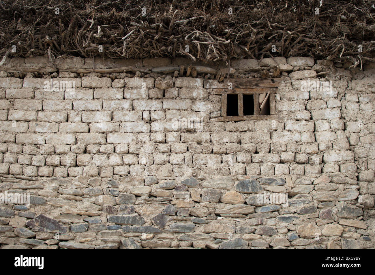 A stone house in the inner Himalaya in India. Locals collect firewood in summer and store it above the house for the long winter Stock Photo