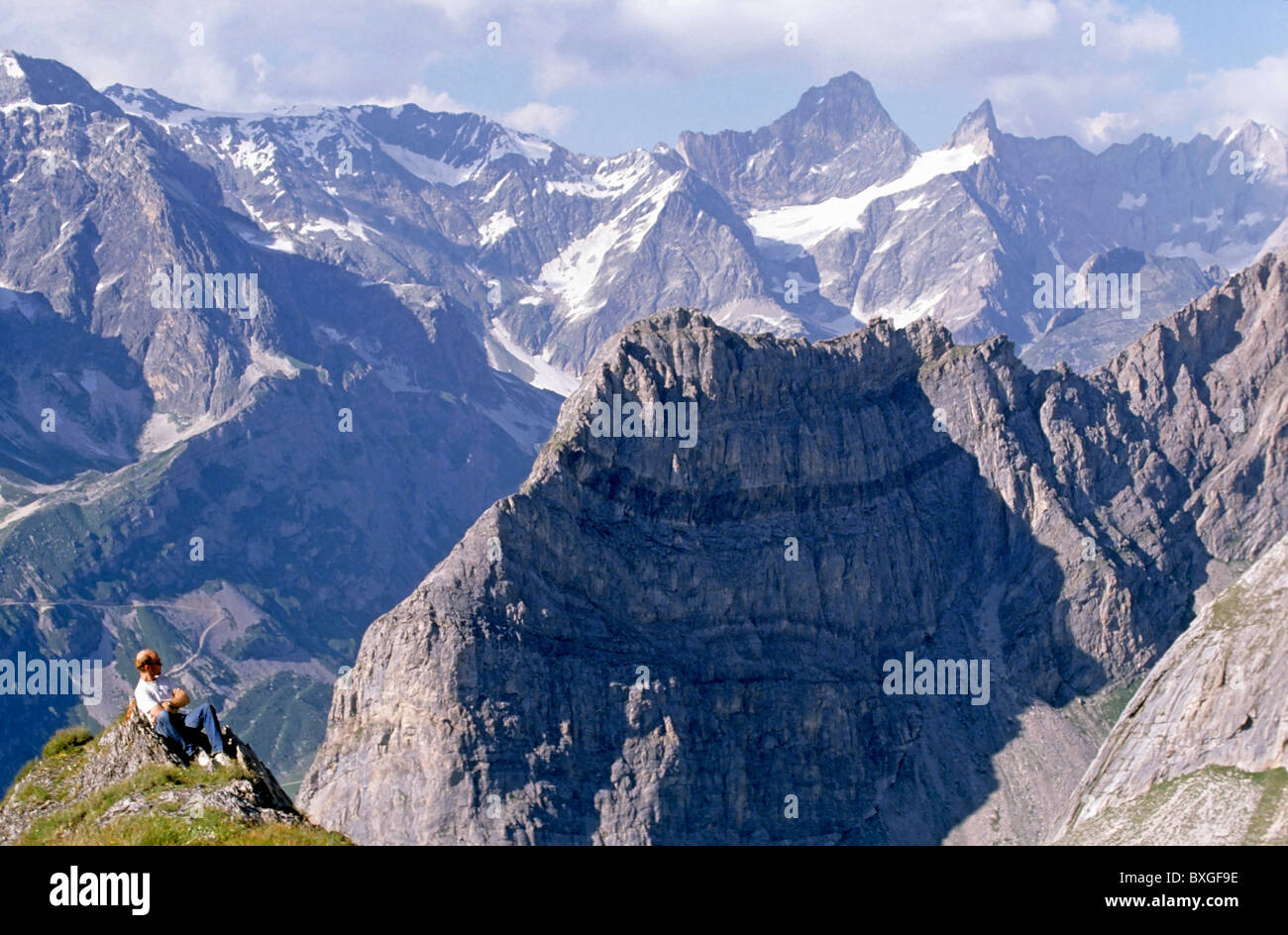 French Alps - Hiker looks down at the view from high up a mountain in the Vanoise National Park, France. Stock Photo