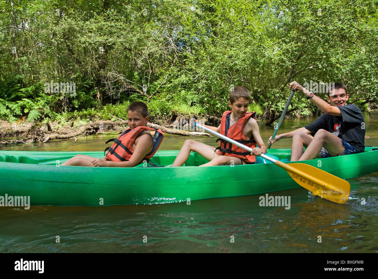Three boys canoeing on the Eyre river, Aquitaine, France. Stock Photo