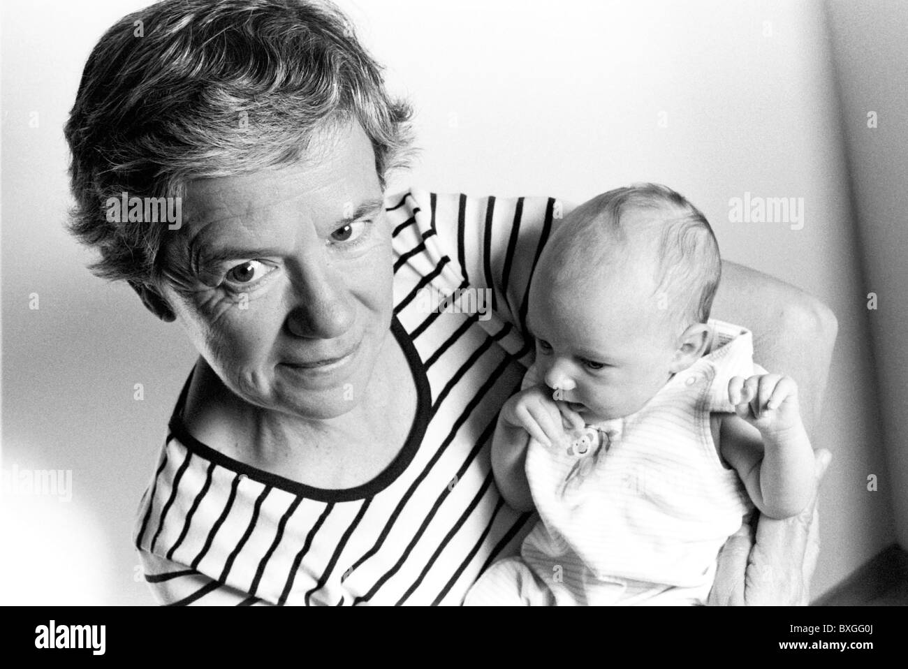 Grandmother holding a new born baby girl in her arms. Stock Photo