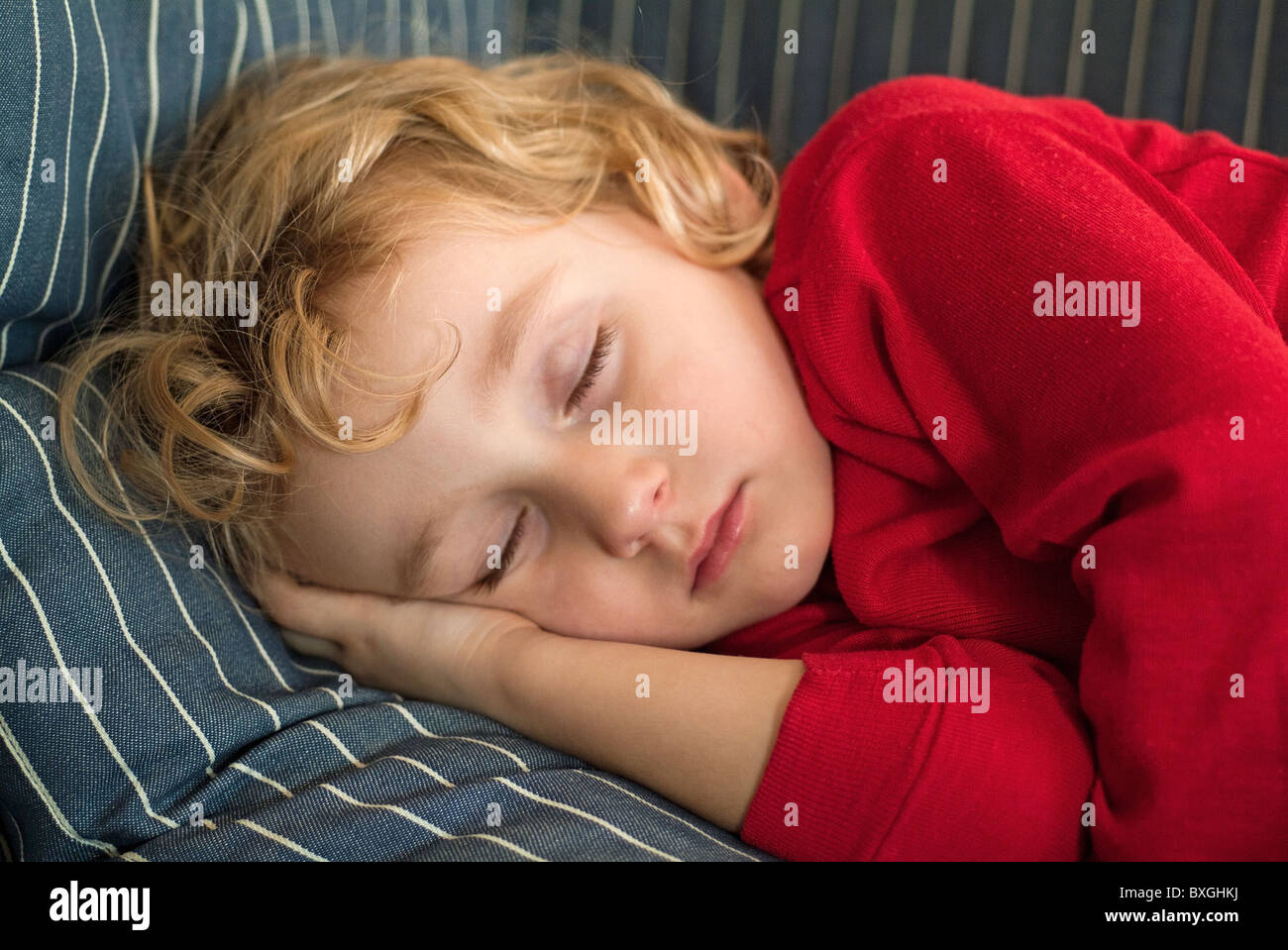 Child sleeping, little tired girl asleep on sofa Stock Photo