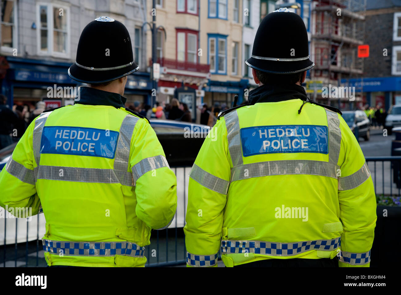 rear view of two welsh Police officers at student protest against education cuts, Aberystwyth Wales UK Stock Photo