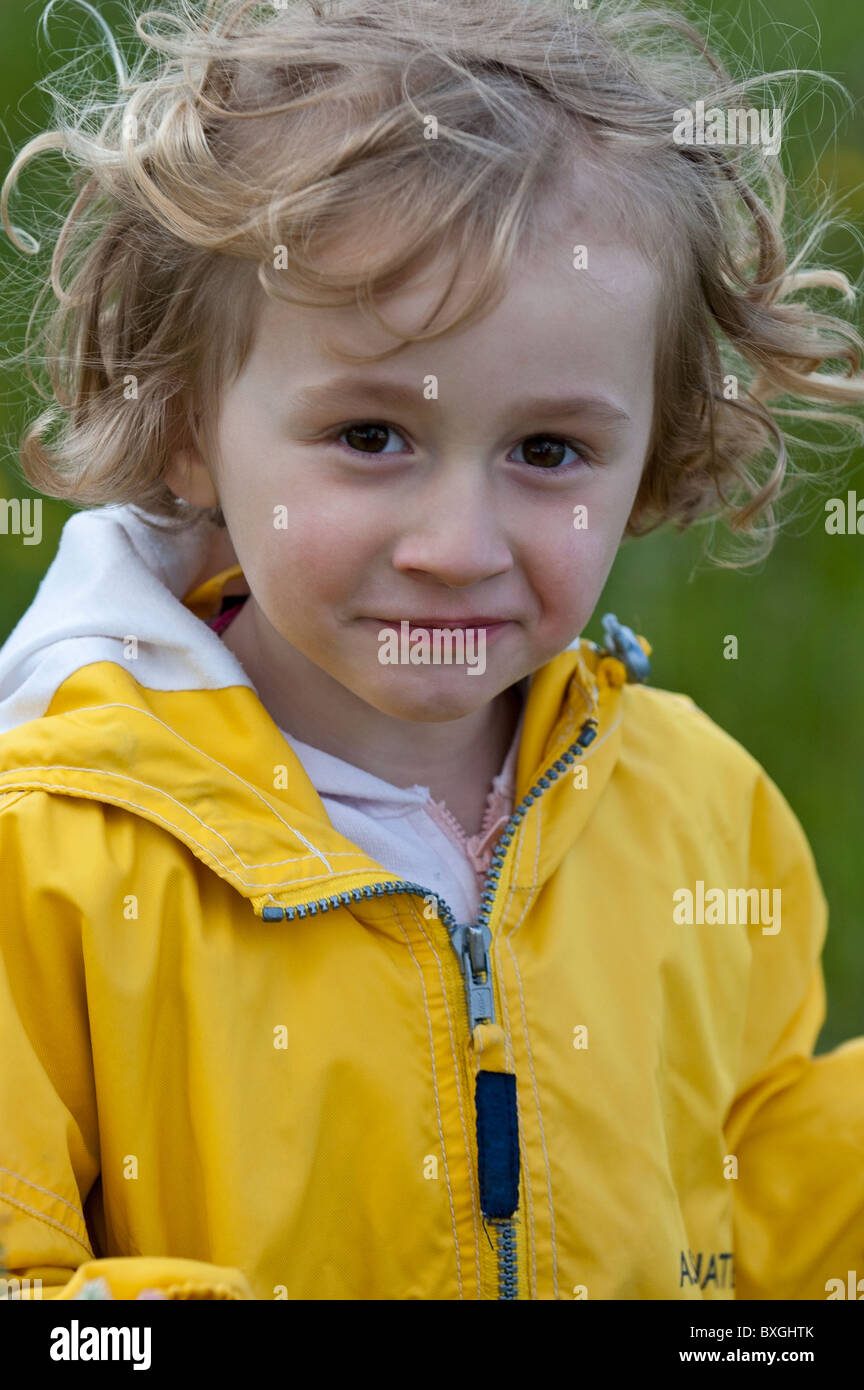 Little girl wearing a yellow raincoat, Provence, France. Stock Photo