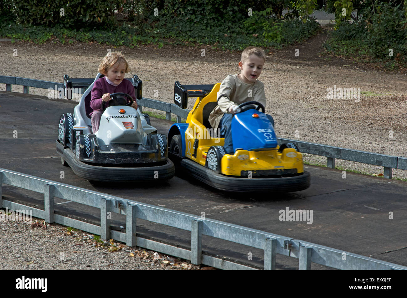 Two children speeding in go karts in an amusement park. Stock Photo