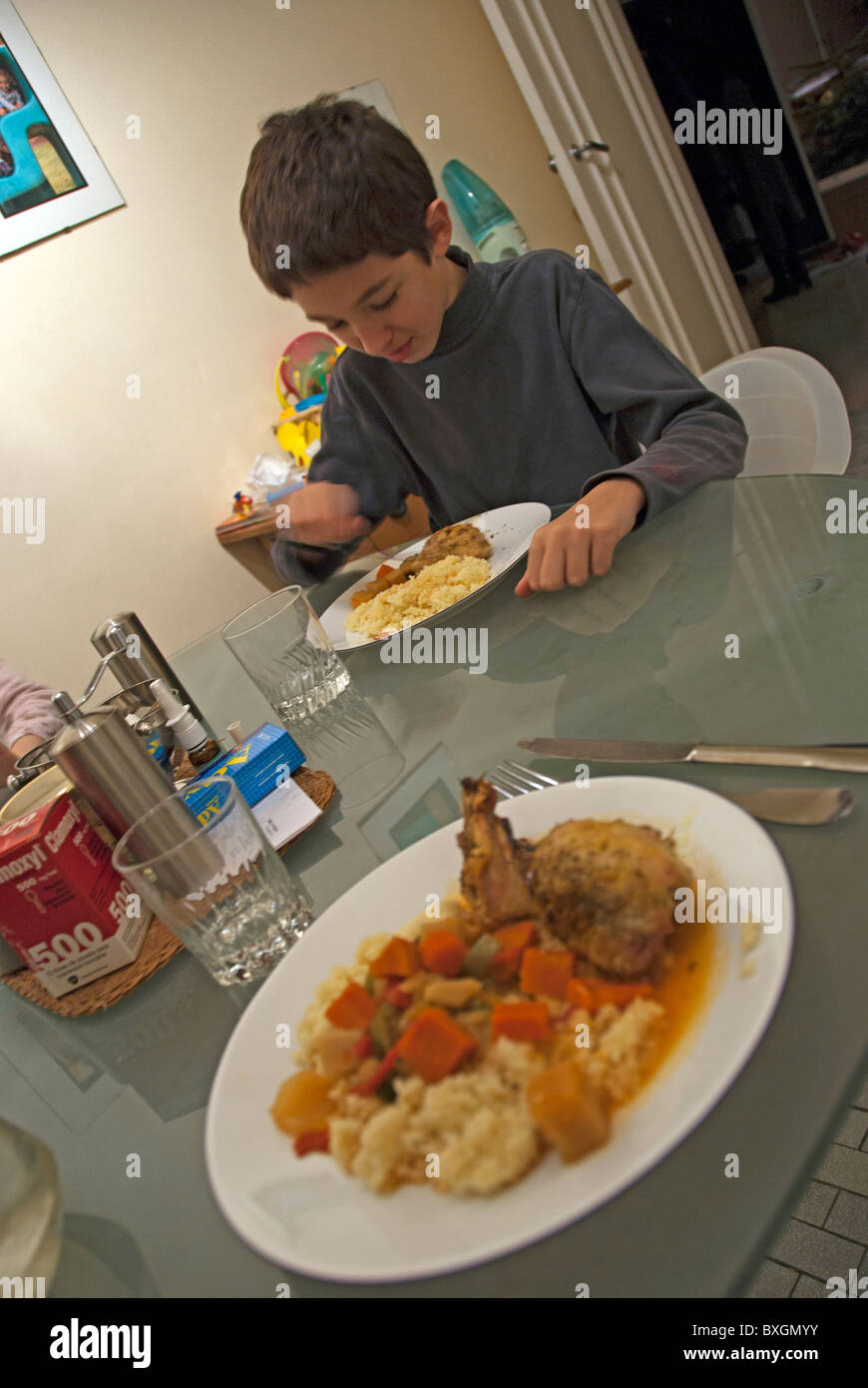 Boy eating dinner at the kitchen table, France. Stock Photo