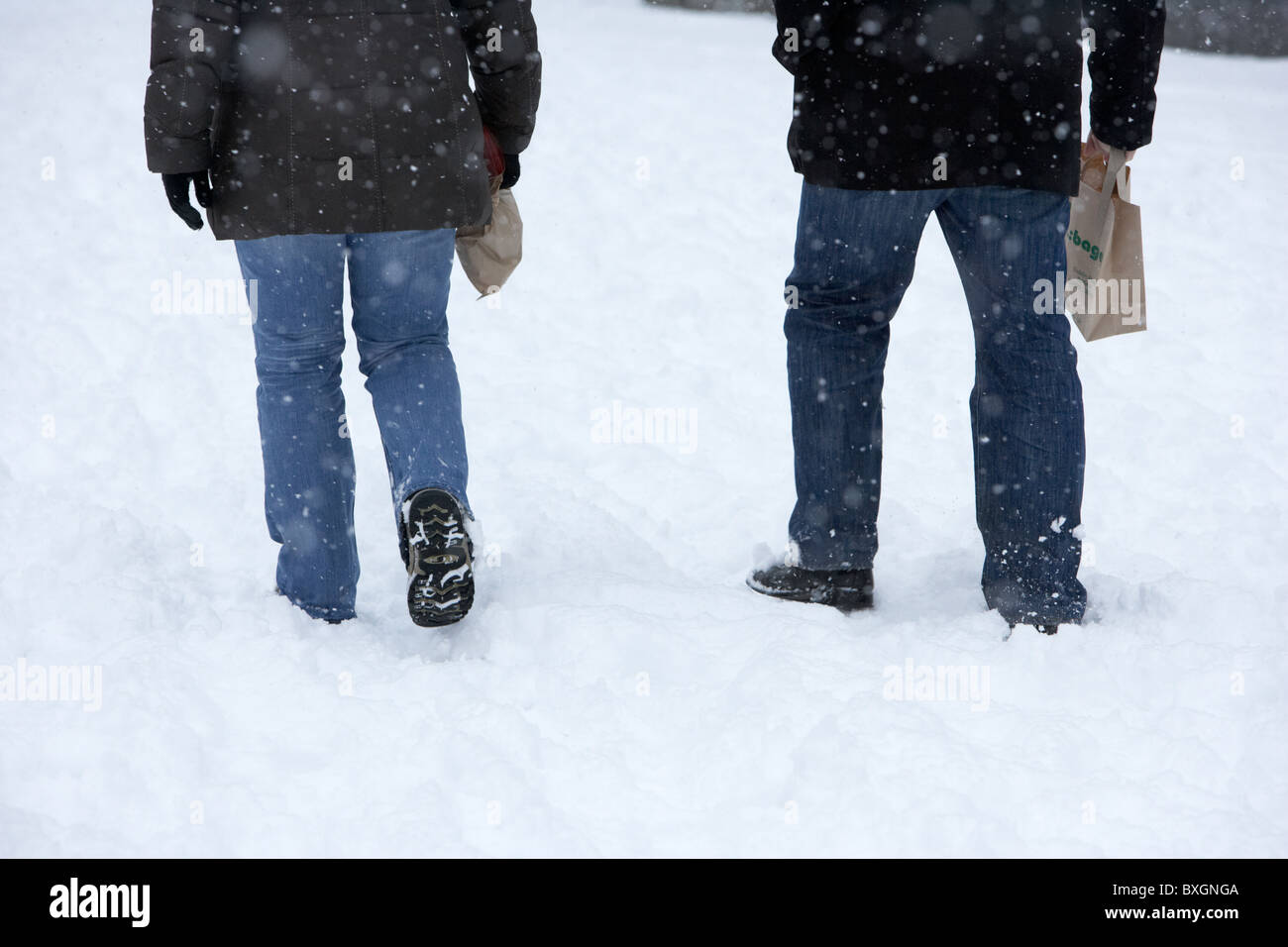 couple walking through deep snow on a cold snowy winters day Belfast