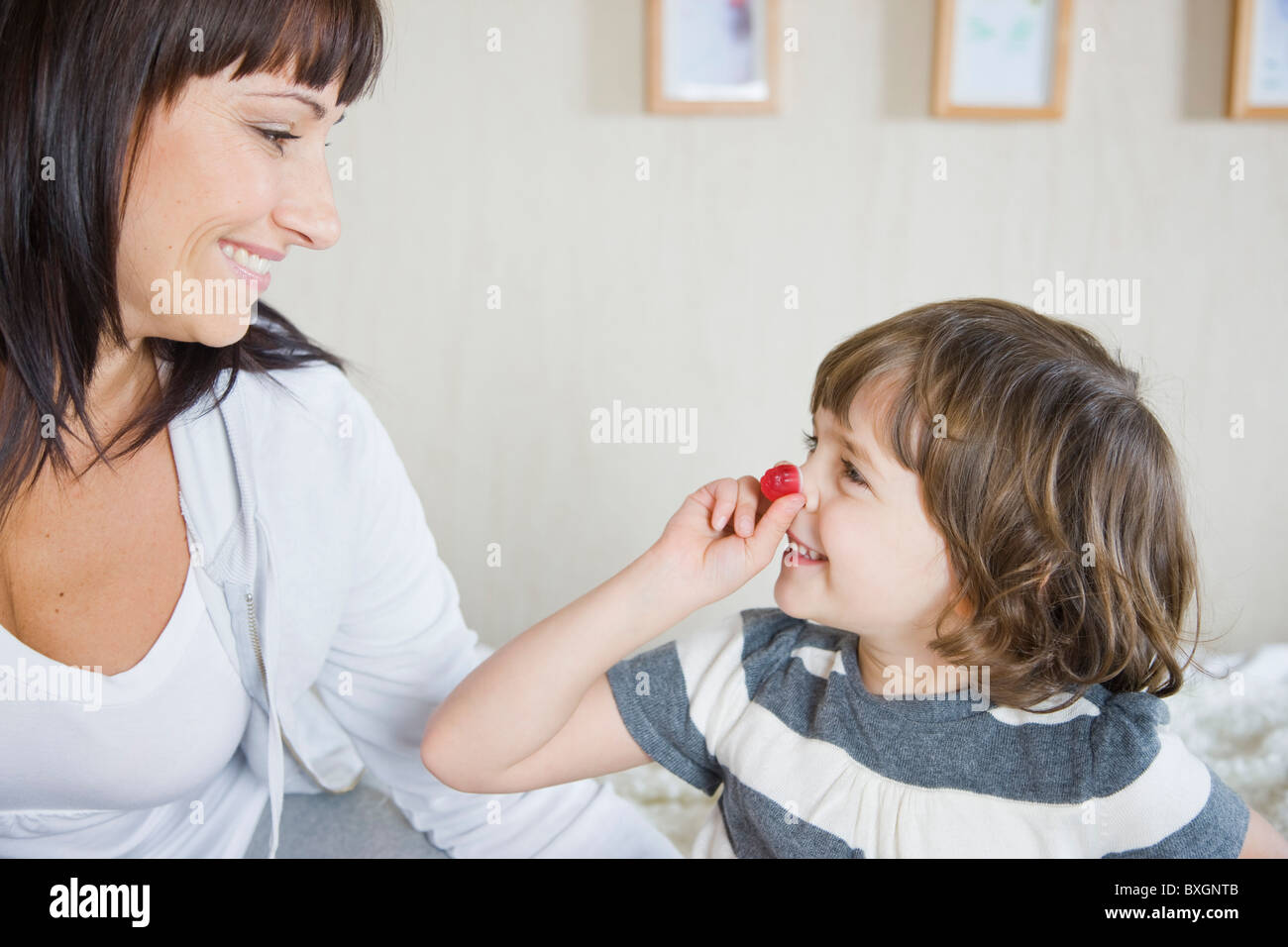 Daughter playing with red sweet Stock Photo