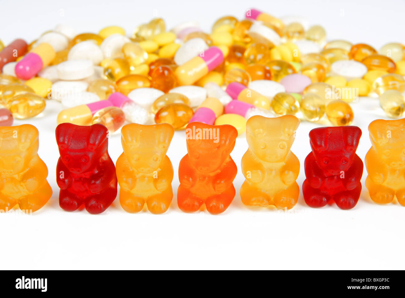 A stack of different coloorful tablets and gummy bears Stock Photo