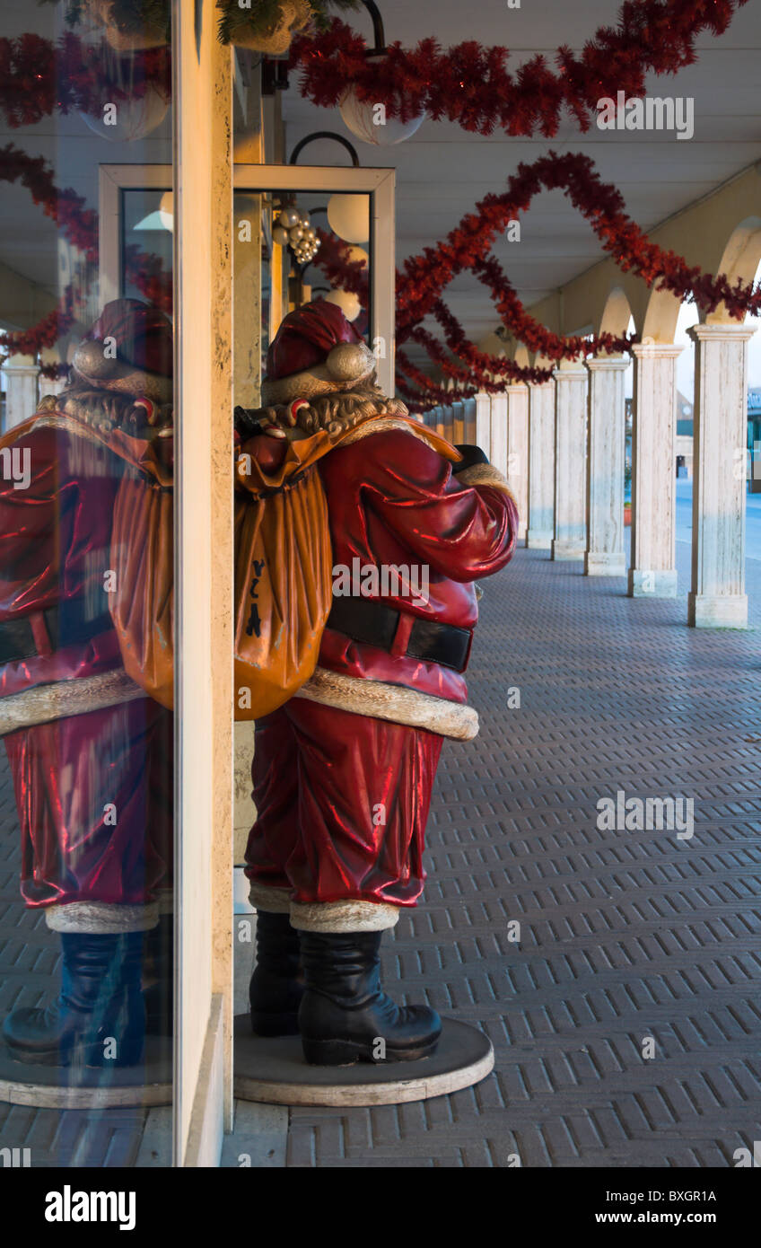 Ostia harbour, Santa Claus dummy by shop at dusk Stock Photo
