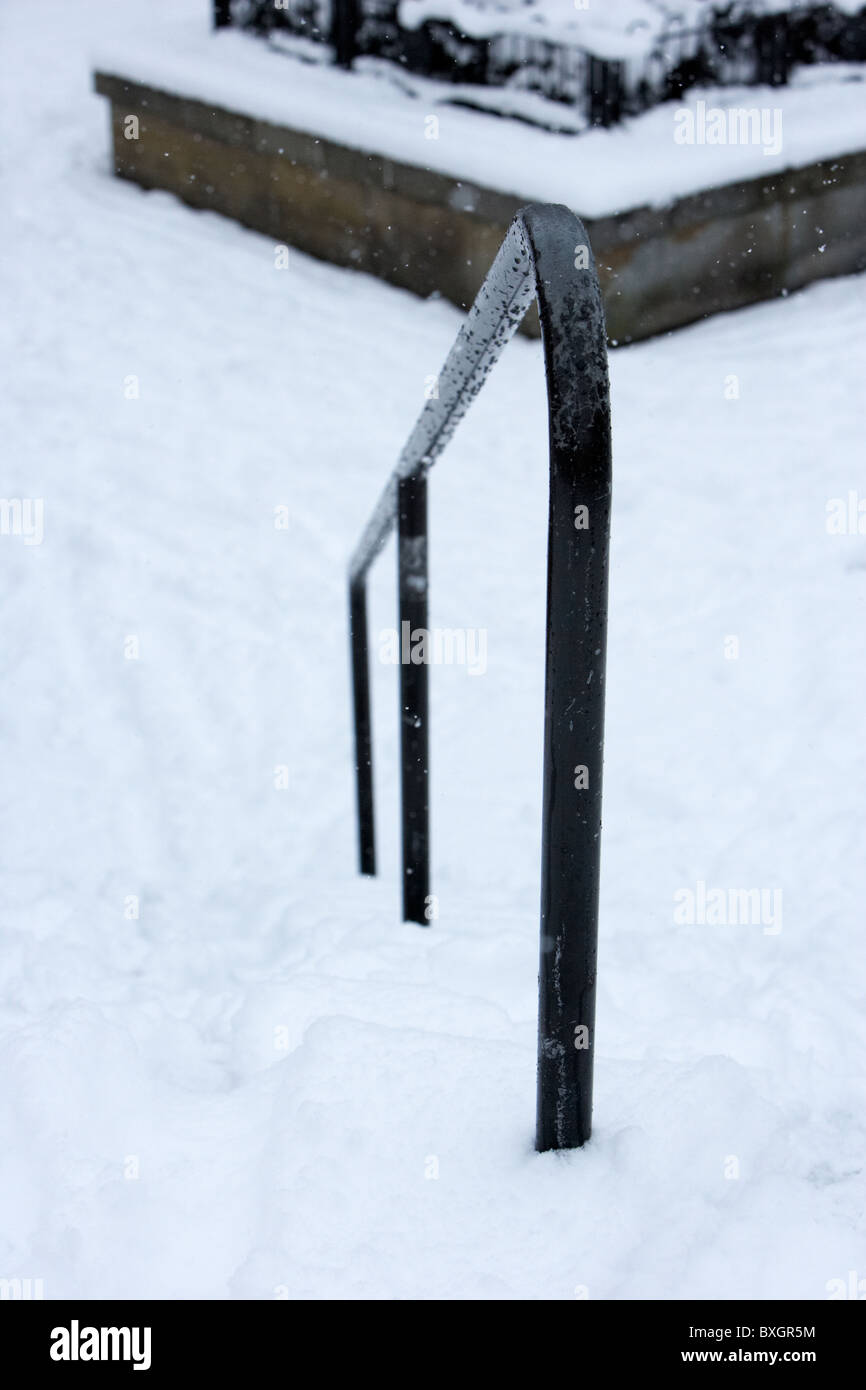 handrail on snow covered steps on a cold snowy winters day Belfast Northern Ireland Stock Photo