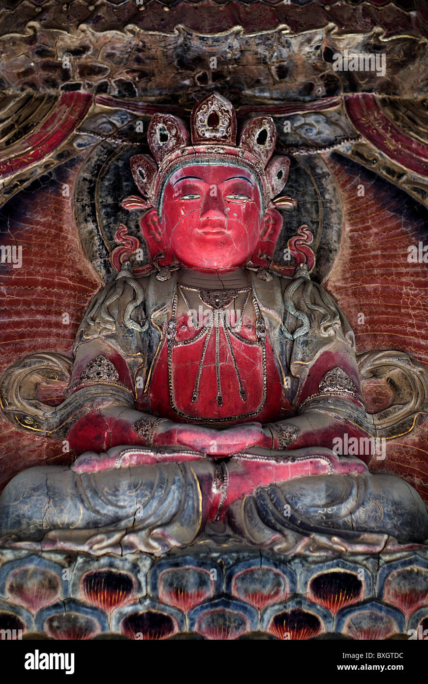 Red statue of Buddha sitting in the Lotus position Stock Photo