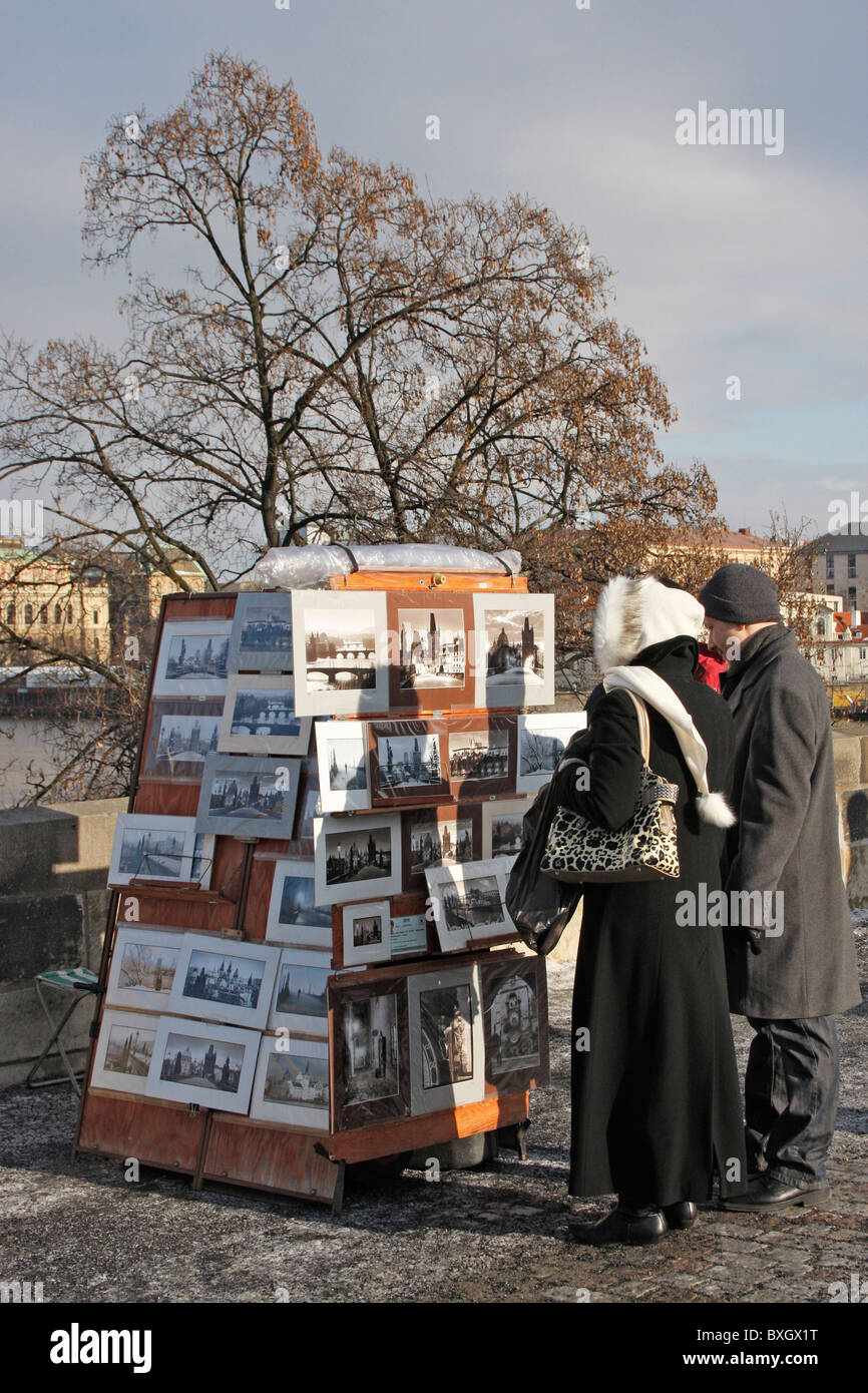 Tourists to Charles Bridge,Prague looking at an artists work.Prague ,Czech Republic. Stock Photo