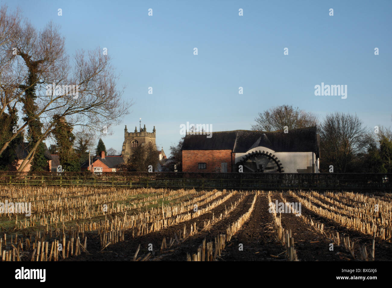 Rossett water mill, church, houses and farm field of harvesteted corn