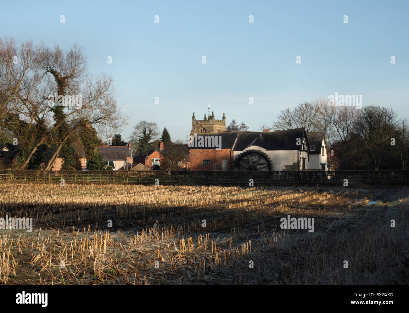 Rossett water mill, church, houses and farm field of harvesteted corn
