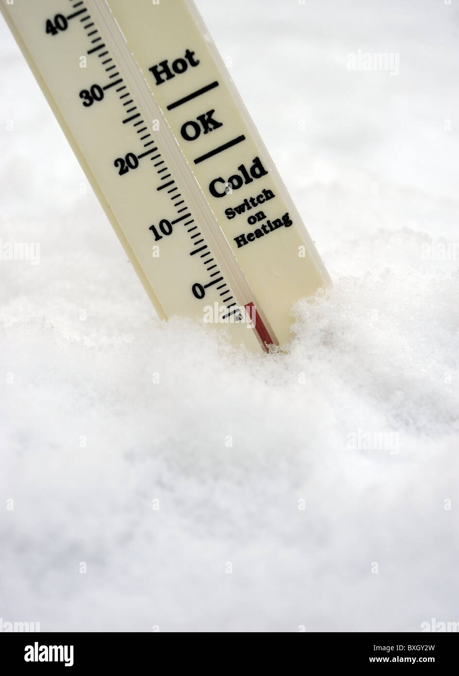 THERMOMETER IN  WINTER SNOW SHOWING MINUS TEMPERATURE WITH SWITCH ON HEATING SIGN UK Stock Photo