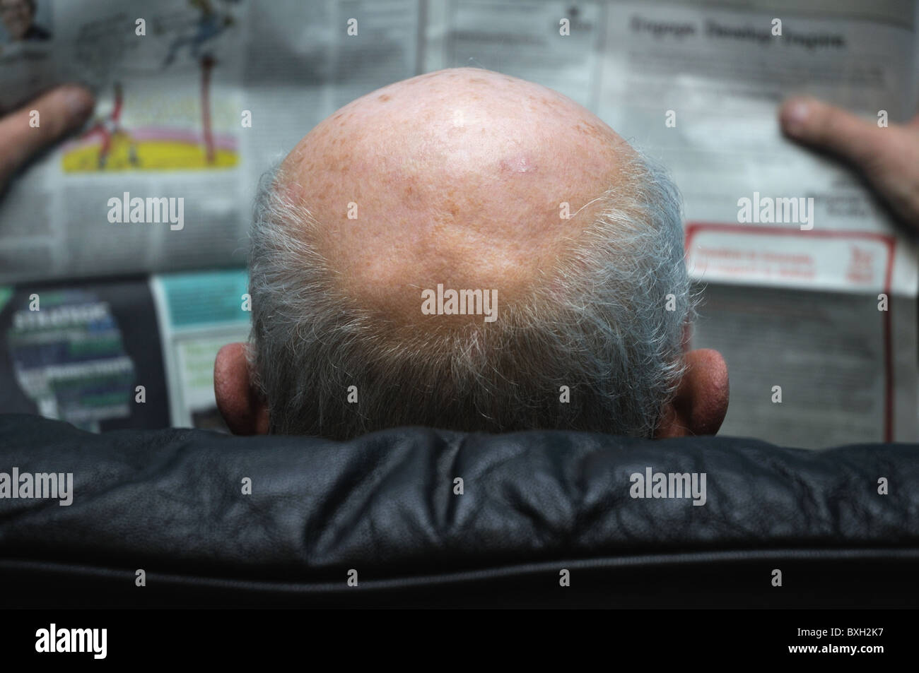 An elderly man reading the paper. Stock Photo