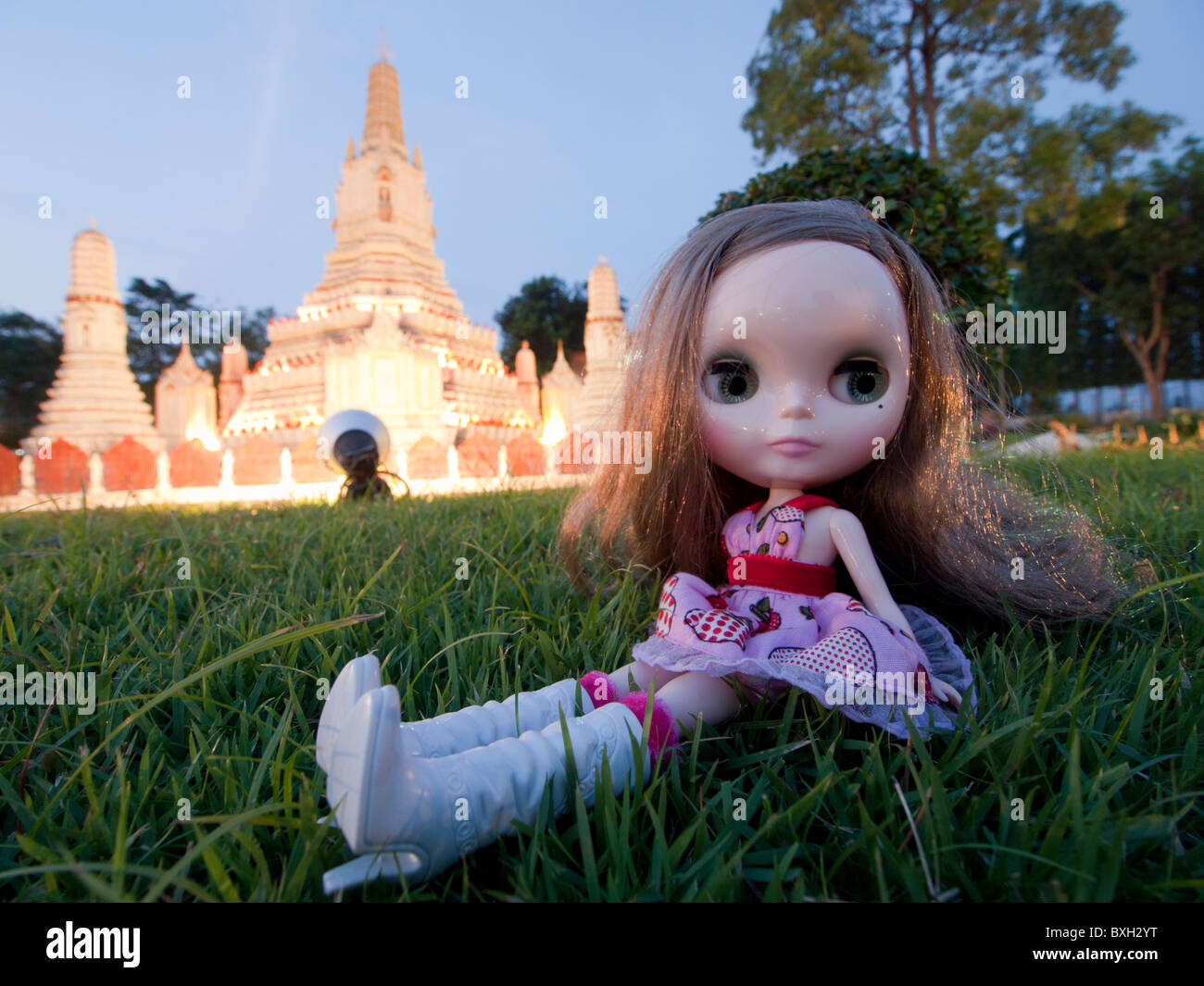 Blythe doll sitting infront of mini Thai temple at Mini Siam Pattaya Stock Photo