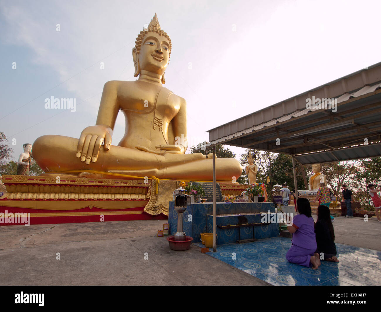 Thai Buddhist praying in front of Big gold buddha image Stock Photo