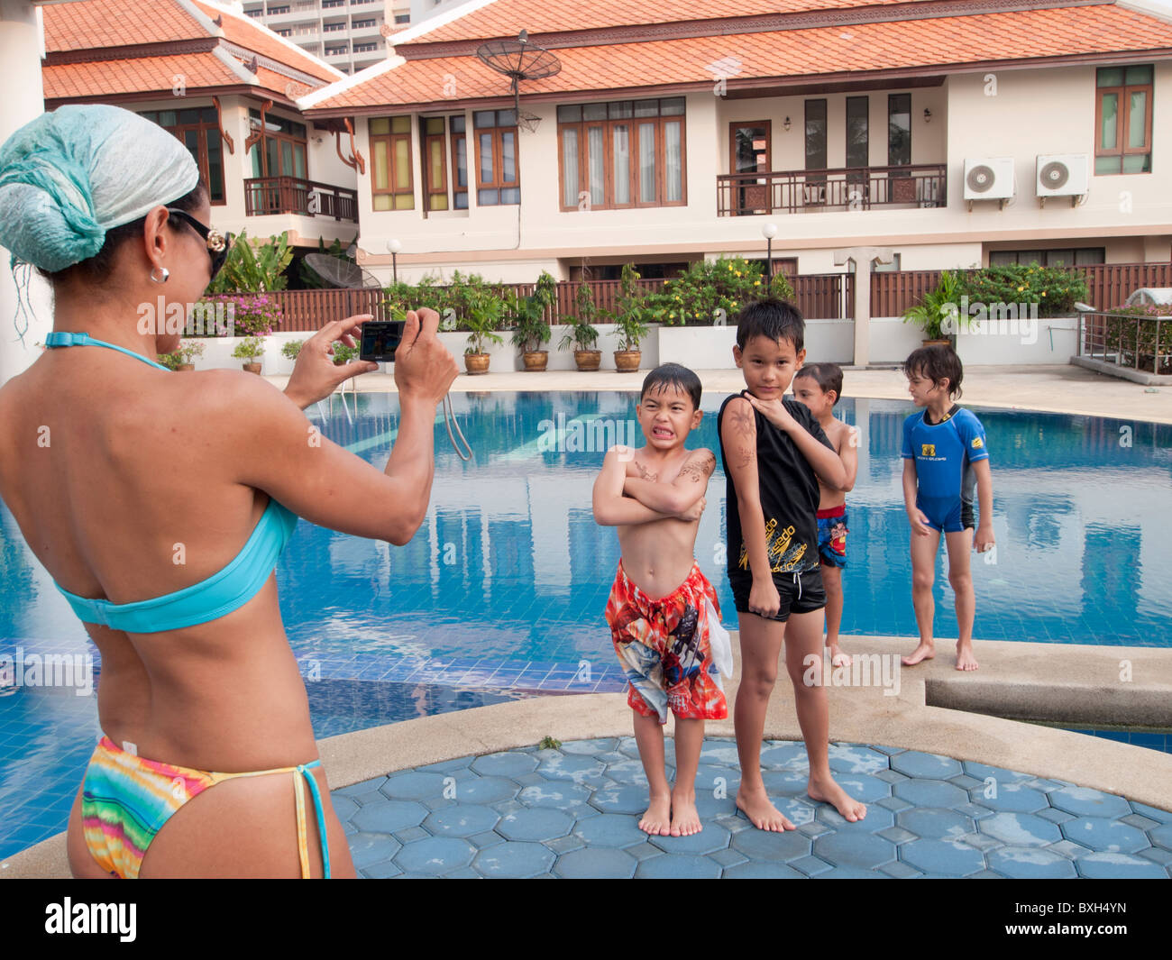 Boys being photographed at the swimming pool by their mother Stock Photo