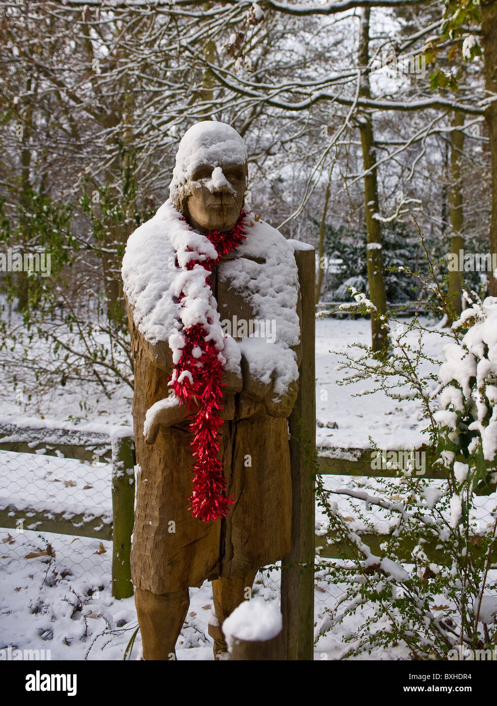 A wooden sculpture covered in snow at Thorndon Park in Essex.  Photograph by Gordon Scammell Stock Photo