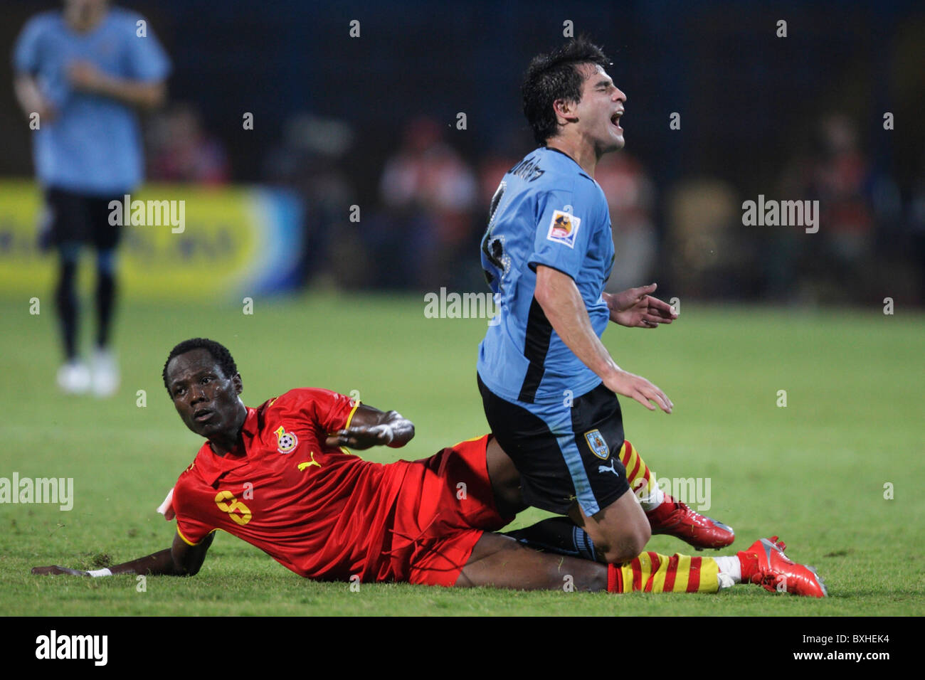 Emmanuel Agyemang Badu of Ghana (l) levels a tackle on Nicolas Lodeiro of Uruguay (r) during a 2009 U-20 World Cup soccer match. Stock Photo