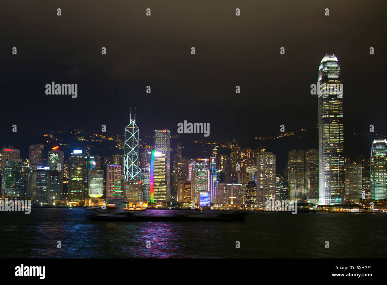 Hong Kong Island China city skyline of Central District at night with light show seen across Victoria Harbour from Kowloon Stock Photo