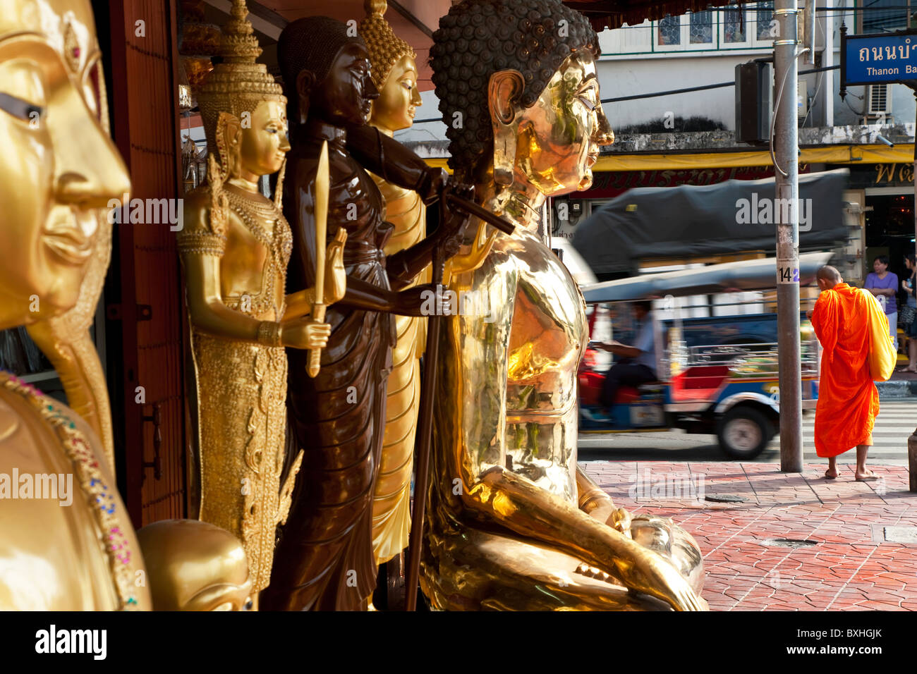 Buddha statues, monks and Tuk Tuk, street scene, Bangkok, Thailand Stock Photo