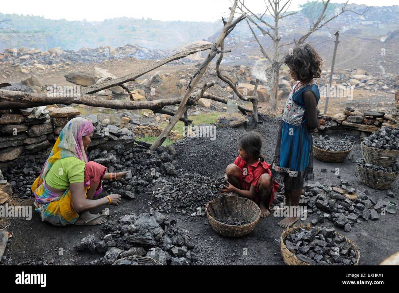 India Jharkhand Jharia children collect coal from coalfields , behind burning open cast coalfields of BCCL Ltd. Stock Photo