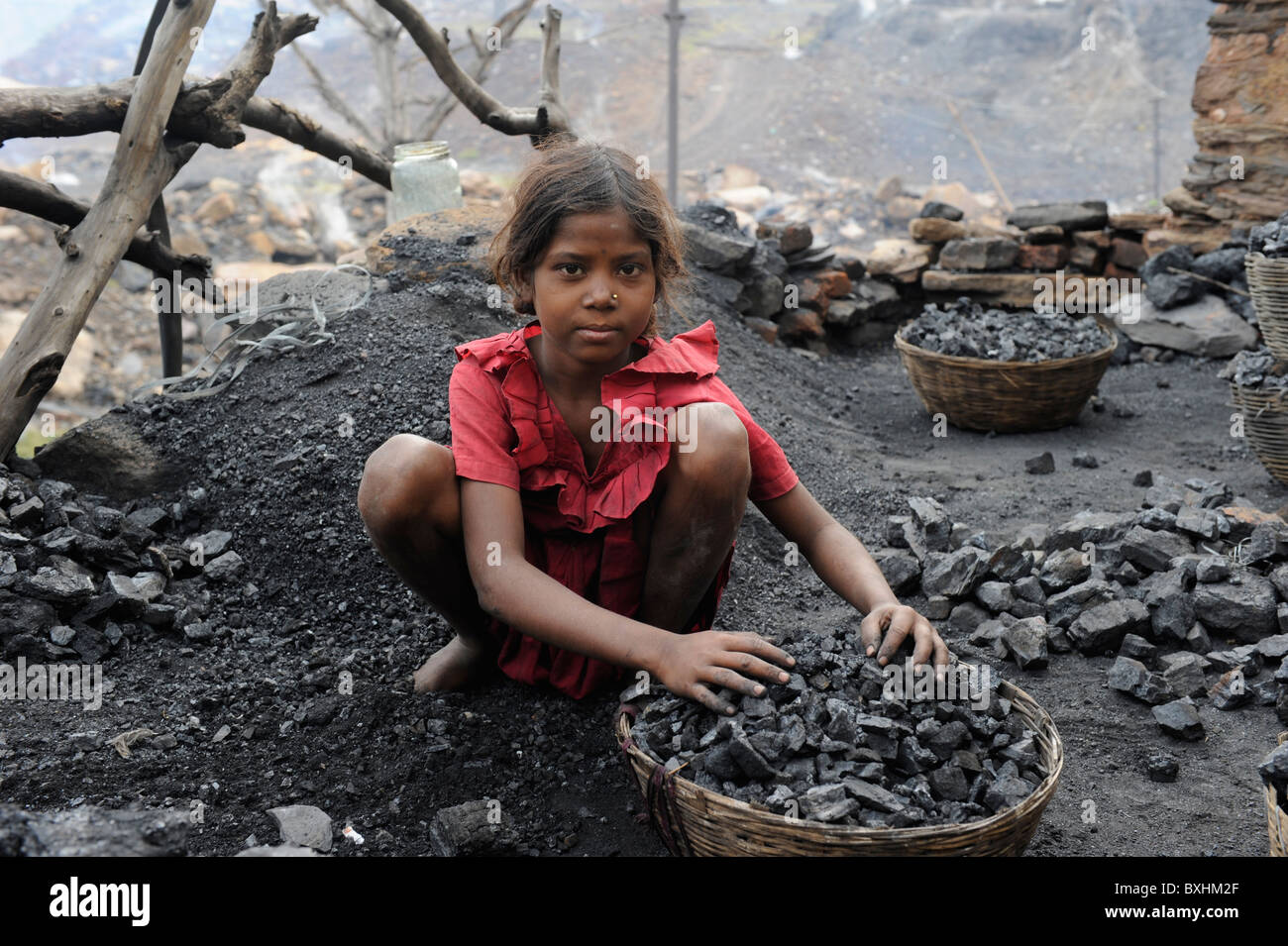 India Jharkhand Jharia children collect coal from coalfields , behind burning coalfields of BCCL Ltd. Stock Photo