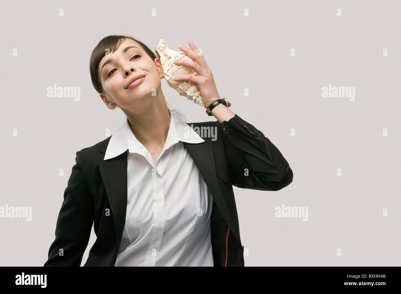Woman holding conch shell ear hi-res stock photography and images - Alamy