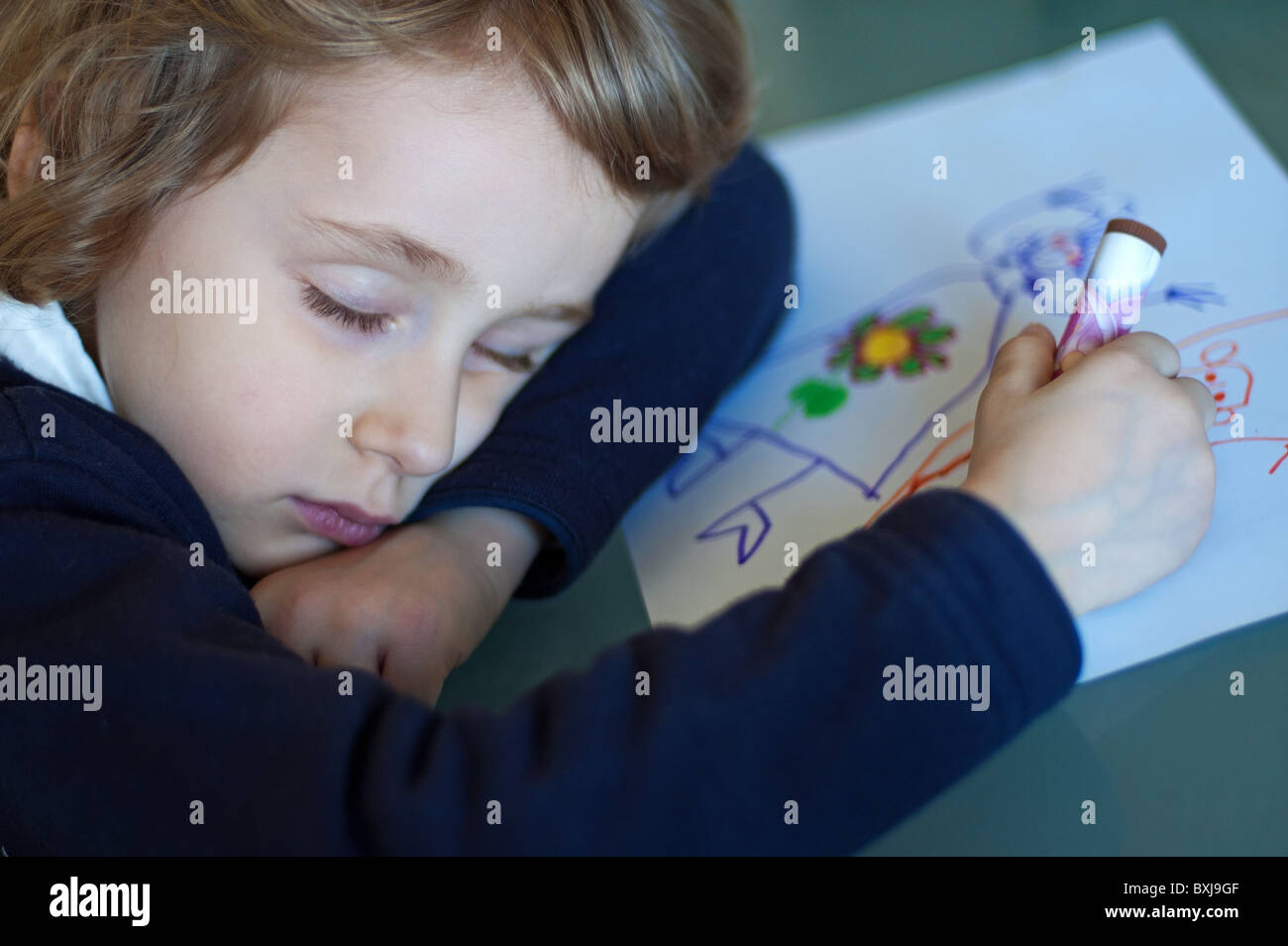 Girl falls asleep exhausted and tired in the middle of drawing a picture for homework Stock Photo