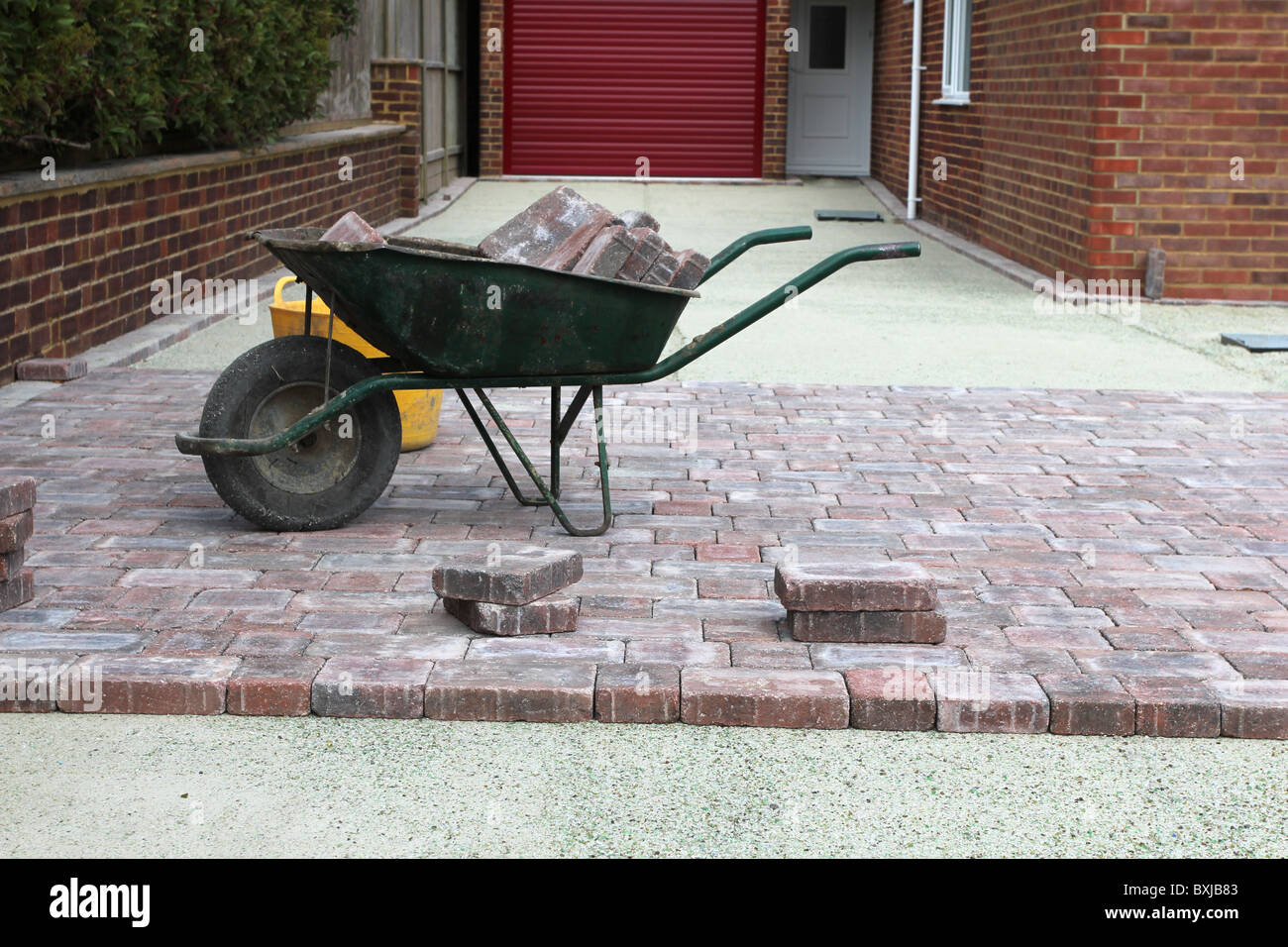 Concrete block paving bricks being laid on a driveway of a house. Stock Photo